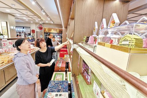 9月22日上午，衡水市区自强街的志兴斋糕点店内，志兴斋第三代传承人高爽（右三）向顾客介绍城市地标文创月饼。 中秋节临近，河北老字号志兴斋推出的城市地标文创月饼受到市民和网友的喜爱。本报记者 焦 磊摄