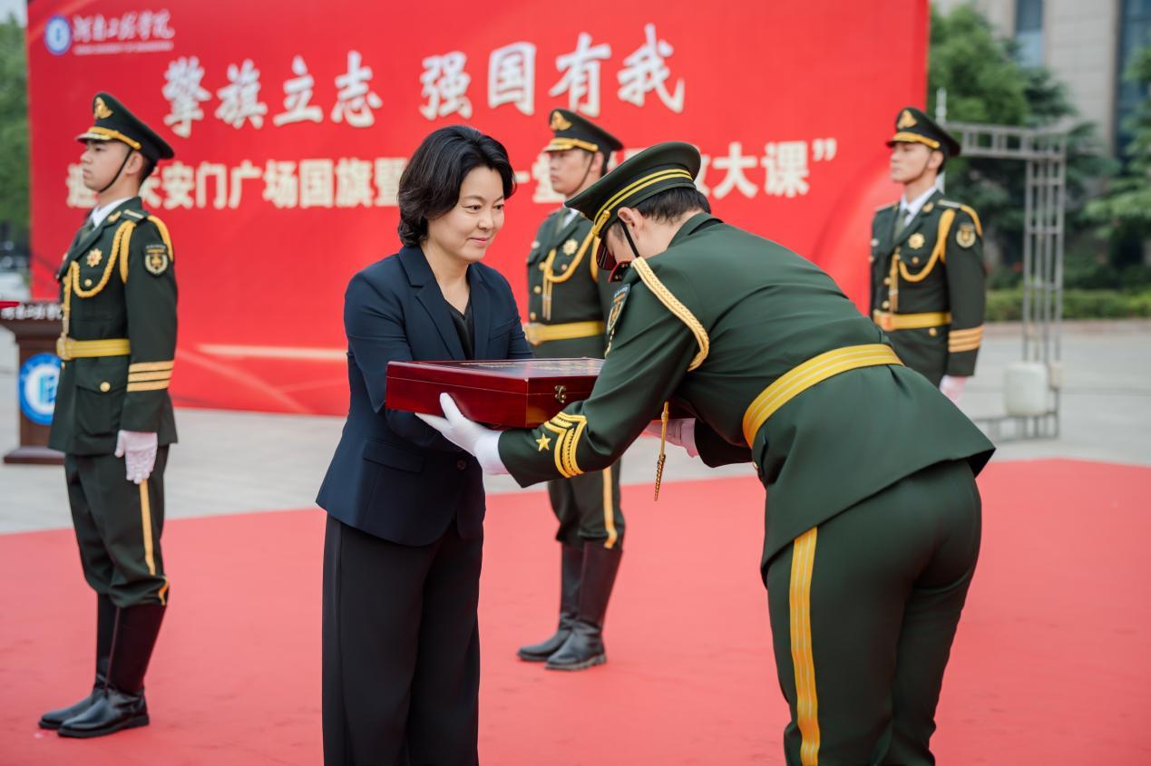 校长李利英将国旗郑重交给靖宇国旗护卫队