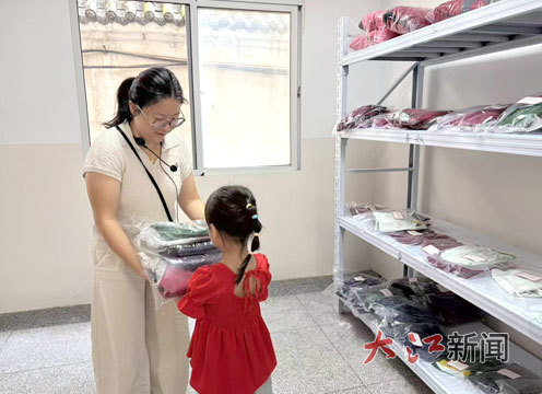 老师将学生捐的校服发给有需要的学生。