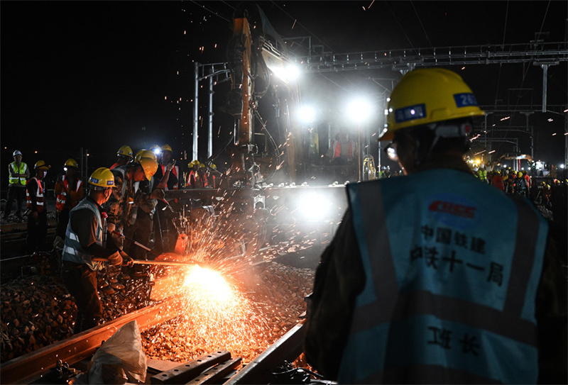 9月22日夜，中铁十一局施工人员在道岔插铺作业现场切割钢轨。