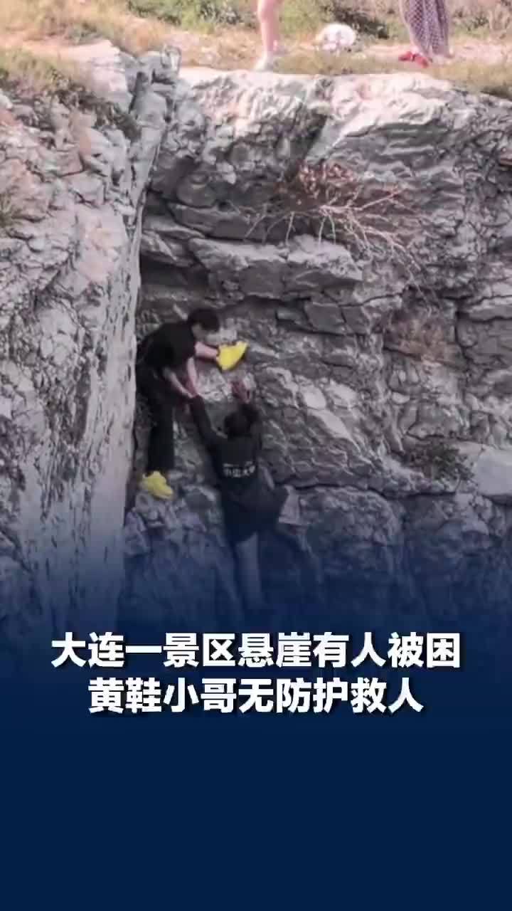 大连一景区悬崖有人被困小哥无防护救人，救人小伙称大叔被困悬崖手一直在抖：我怕他等不到绳子来