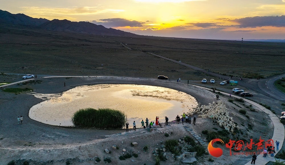 四百年的古龟城守着这方蓄水涝池,夕阳把天地晕成暖橙色调,旅人把这份温柔暮色完整收进了镜头里。