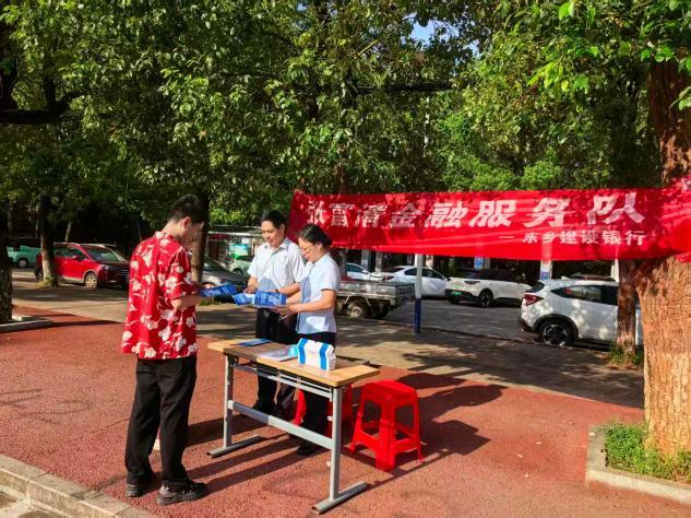 工作人员向教职工发放金融知识宣传手册(邱缪琛 摄)