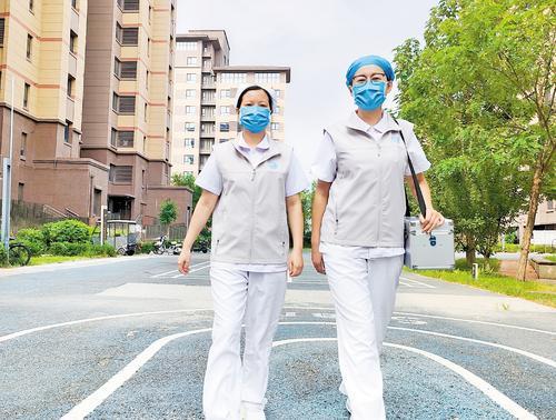 近日,“雄小护”医疗服务队队员张佳新(右)和吴文丽来到居民小区,提供上门护理服务。本报记者 康晓博摄