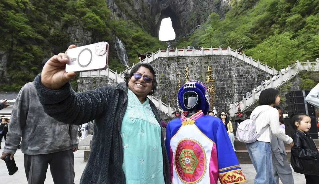 外国游客在天门山景区与人形机器人合影。图/邵颖