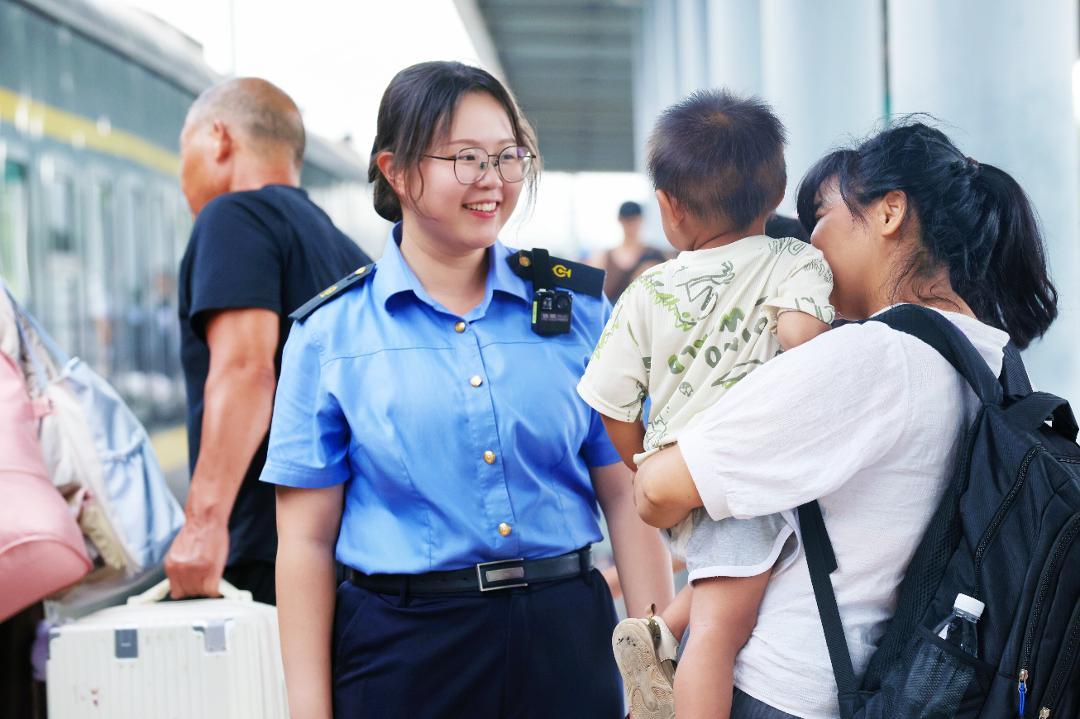 抚州站工作人员耐心引导携带儿童的旅客乘车。(涂家婷 摄)
