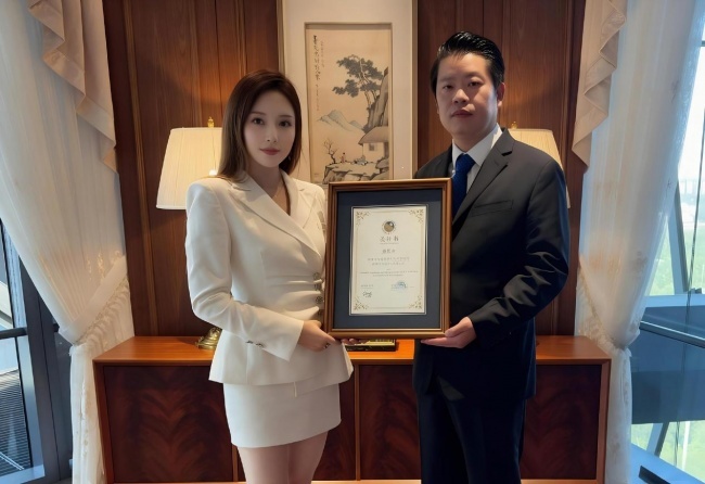 东盟经济贸易促进会会长波尚琅先生(右)亲手将烫金的文化顾问委任牌授予青青女士(左)