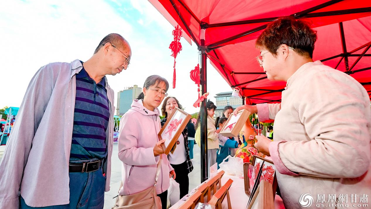 现场设置文明集市,市民选购非遗剪纸作品。