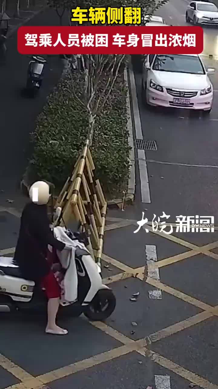 车辆侧翻 驾乘人员被困 车身冒出浓烟 街头一群人冲了上去“搭把手！一起抬”