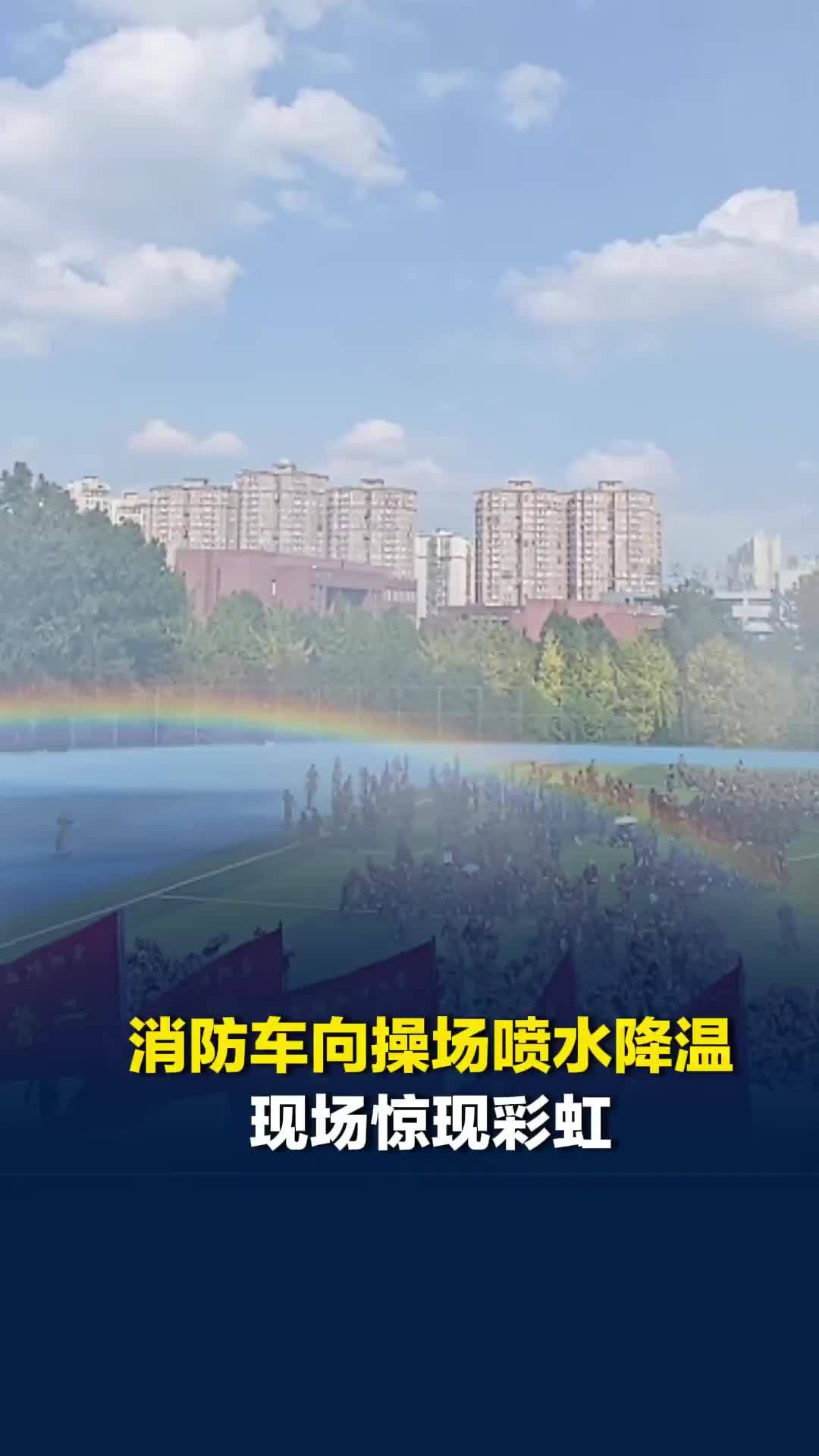 军训时赶上学校消防演练，消防车向操场喷水降温，现场惊现彩虹