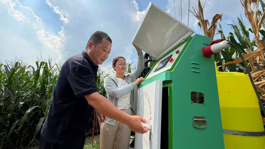 武城县农业综合服务中心副主任李敏在指导种粮大户王庆亮使用水肥一体化设备。(受访者供图)