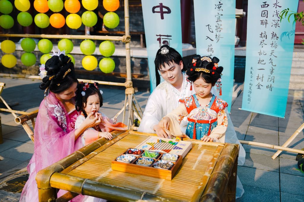 游客身着汉服和大宋不夜城的NPC(右二)弈棋、品食。新华社发