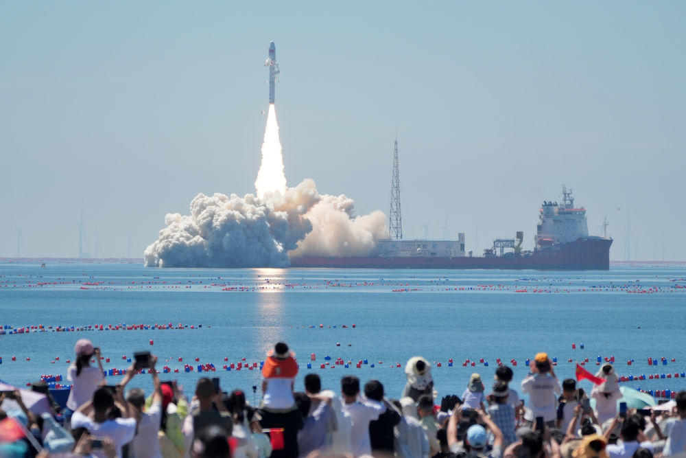 8月5日,游客在海阳见证火箭海上发射。新华社发(唐克 摄)