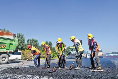 9月3日,京雄高速公路二期项目向阳枢纽互通匝道桥施工现场,建设者在进行沥青路面摊铺作业。本报记者 许佳奇摄