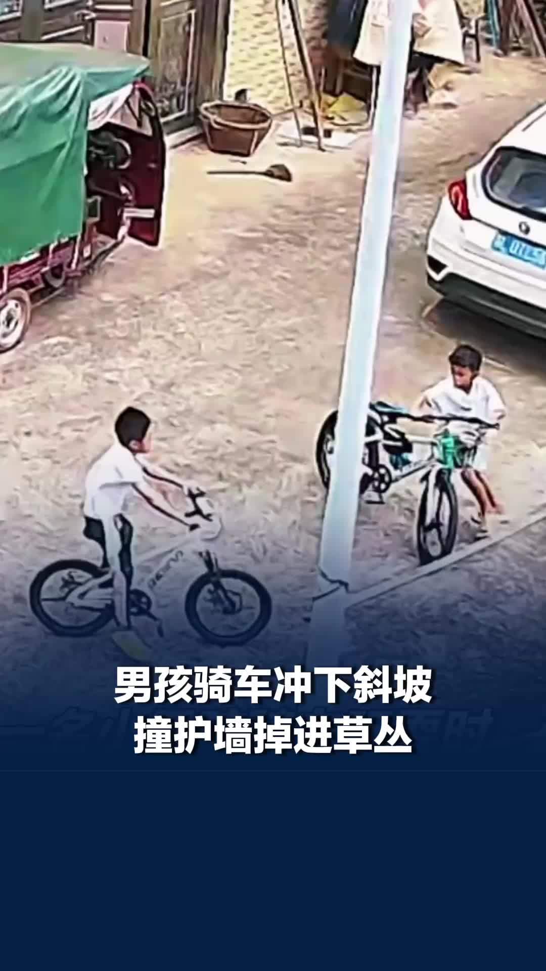 男孩骑车冲下斜坡撞护墙后掉进草丛