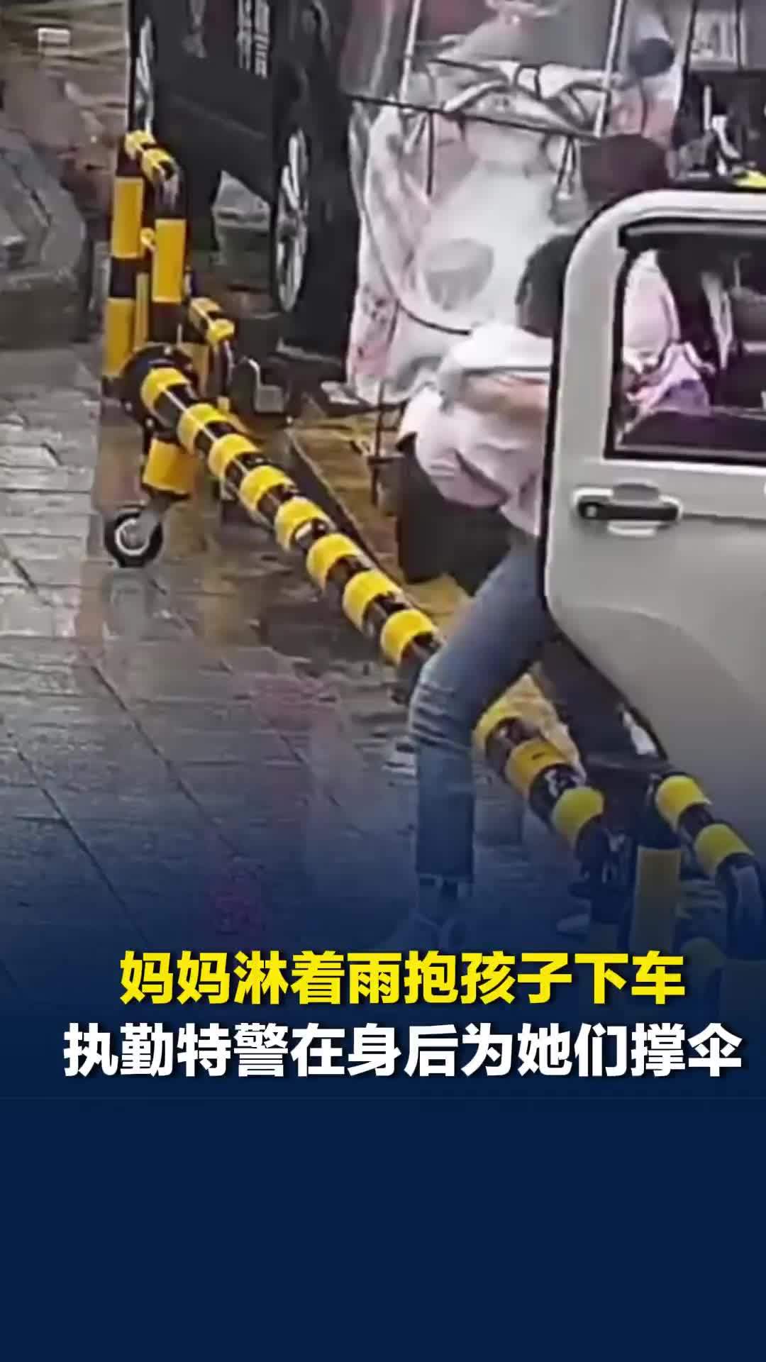 妈妈淋着雨抱孩子下车，执勤特警见状默默跟在身后为她们撑伞