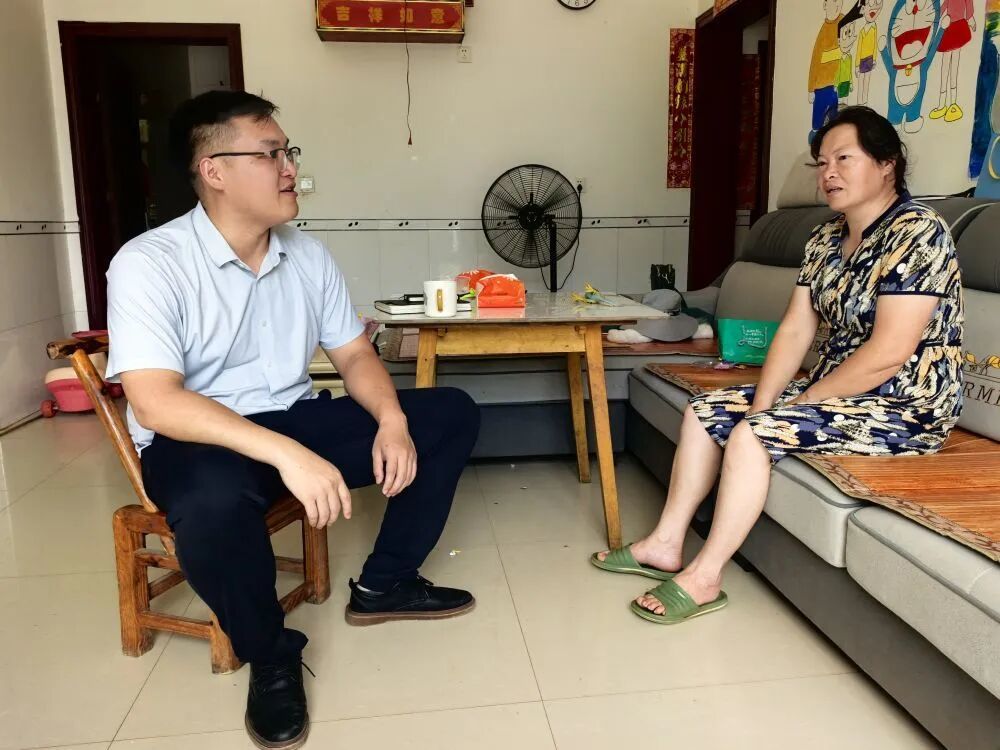 2025年6月17日，李隐（左）在湖南省宁乡市夏铎铺镇兴旺村一户村民家走访。图源：红星云