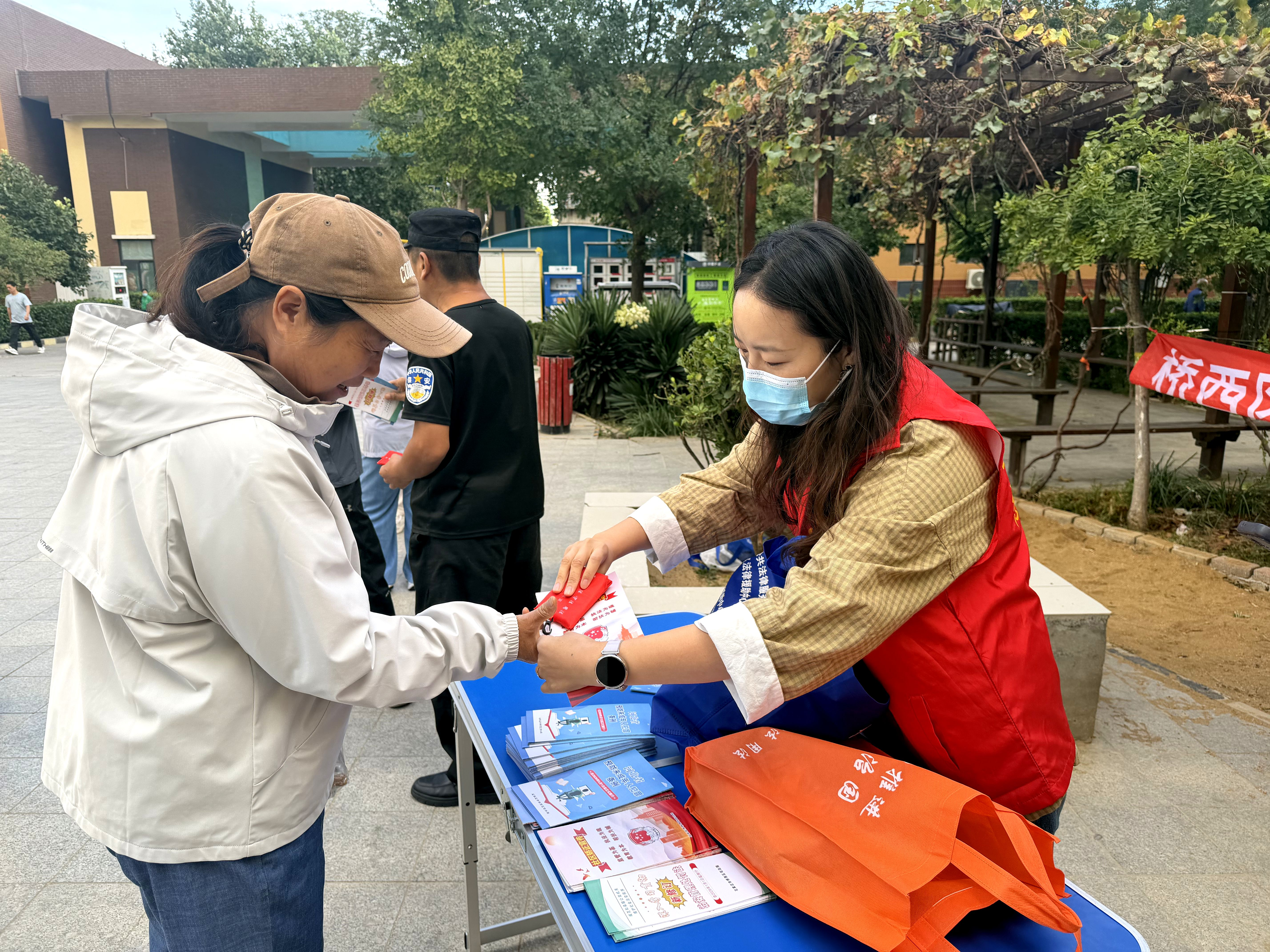 9月30日,在元北路社区东风小区,志愿者向居民发放法治宣传资料。