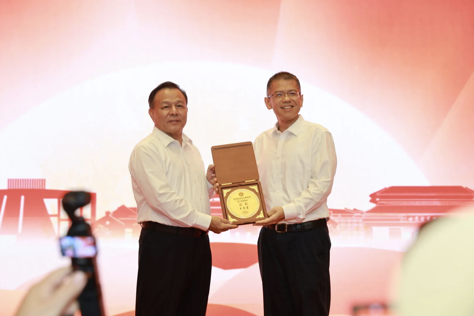 梅州市领导崔毅向新当选的客联会王忠豪会长颁牌