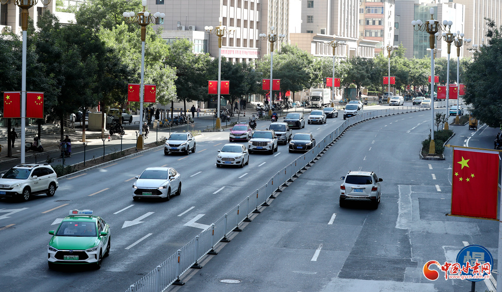 庆阳路两侧路灯杆上整齐悬挂五星红旗，成为街头一道亮丽风景。
