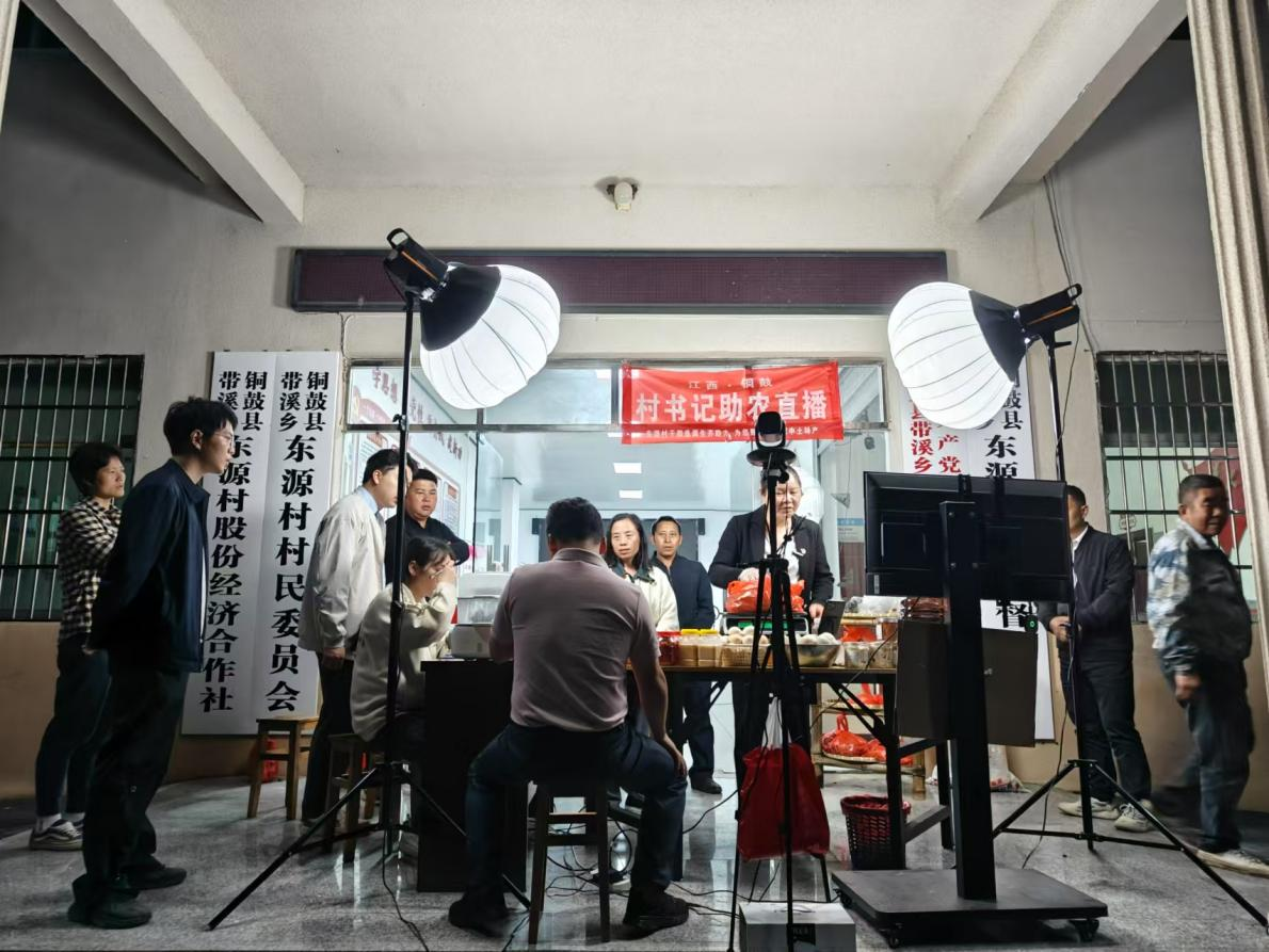 谢昌菊在村委会大门口开启直播,介绍本土农特产品。铜鼓县委网信办供图
