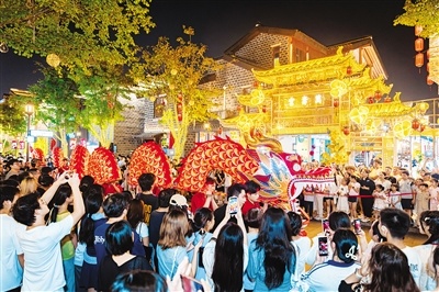 万寿宫历史文化街区内“非遗”板凳龙巡游穿行街巷，吸引市民游客观看。