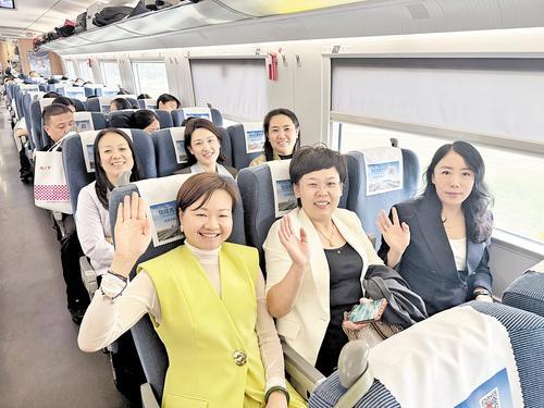 9月28日8时多,在首班复兴号G8854次列车上,旅客正在挥手示意。本报记者 吕若汐摄