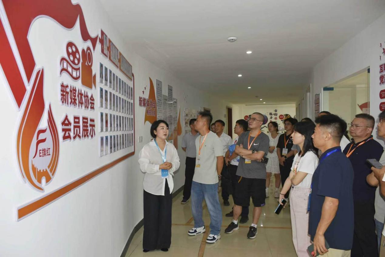 “E旗红”新媒体协会会长龚雪向采风团介绍协会会员展示墙。吴思雨 摄