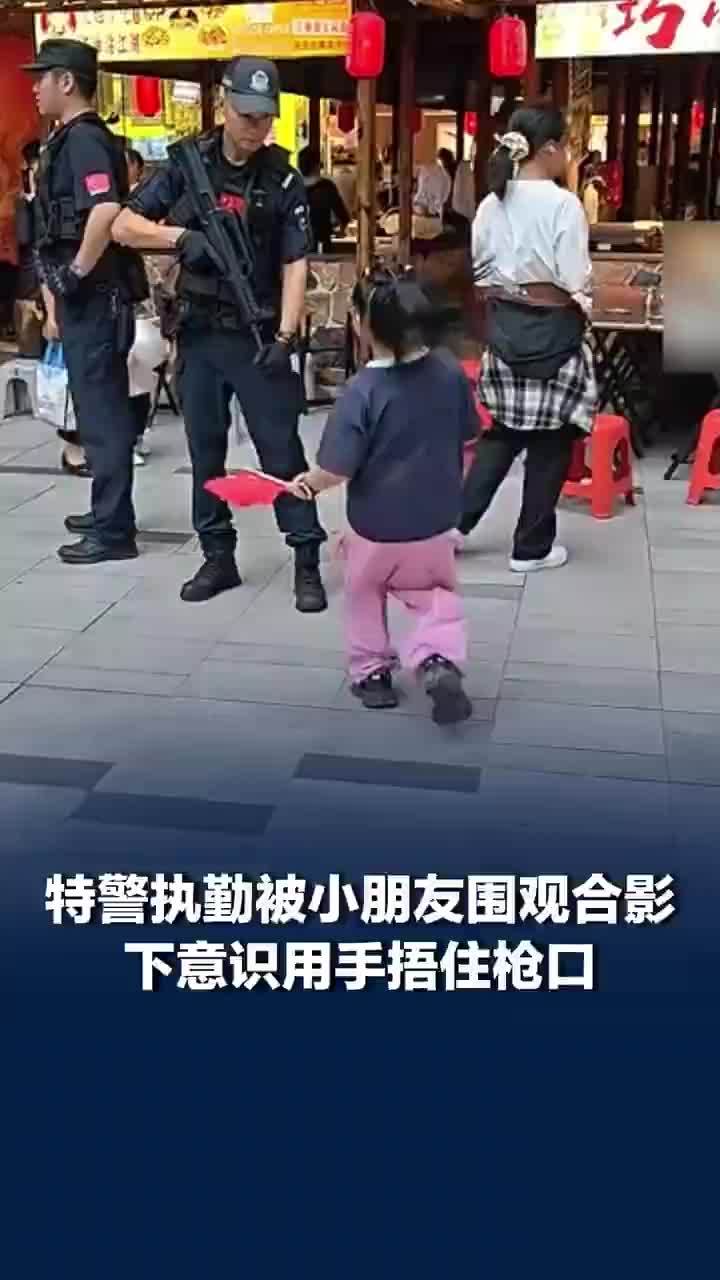 小朋友求合影特警捂住枪口