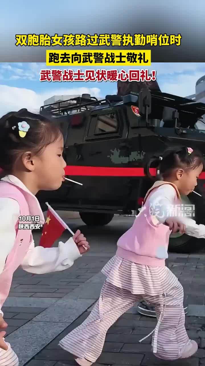 双胞胎女孩路过武警执勤哨位时跑去向武警战士敬礼，武警战士见状暖心回礼