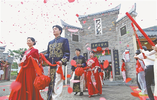 赣州市客家集体婚礼暨移风易俗优秀剧目展演活动在石城县大畲村举行,来自赣州各县(市、区)的30对新人手牵红绣球,正缓缓步入仪式现场。通讯员 陈钰芳摄