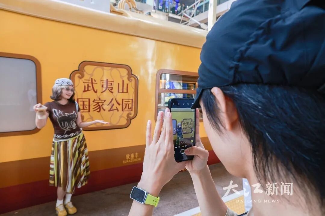 旅客在“武夷山国家公园号”列车旁打卡拍照留念。韩毅 摄