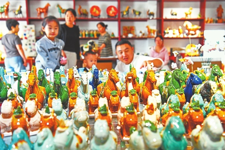 10月3日，游客在洛阳市孟津区朝阳镇南石山村“三彩小镇”挑选文创产品。白水平 摄