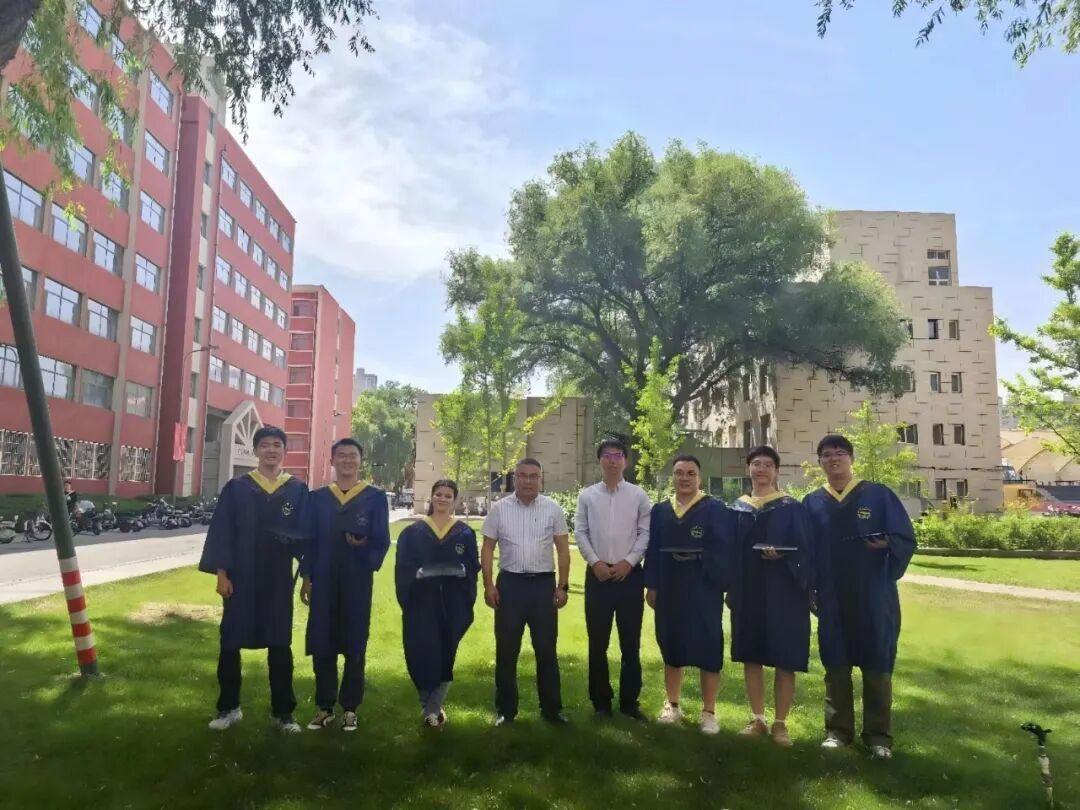 毕业季时，玛丽与导师、同学们在兰州大学校园草坪上合影留念。