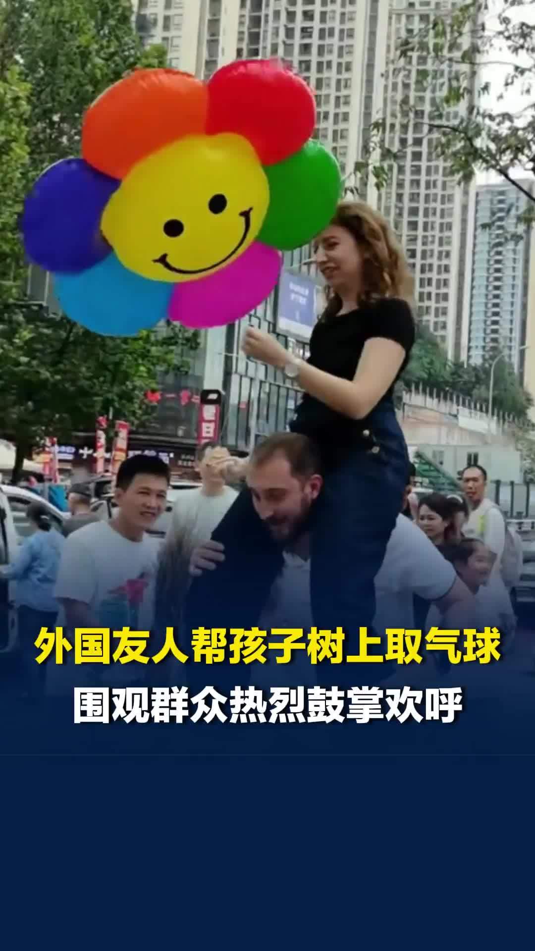 国庆假期重庆街头现暖心一幕：外国友人帮孩子树上取气球，围观群众热烈鼓掌欢呼