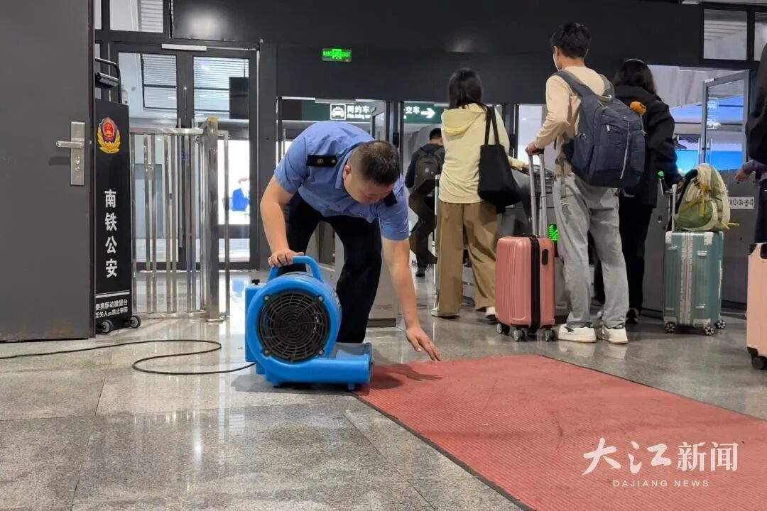 为了雨天旅客安全出行,婺源站的工作人员铺设防滑垫,启用鼓风机。杨佳煜 摄