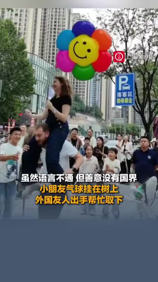 小朋友气球挂树上外国友人出手帮忙