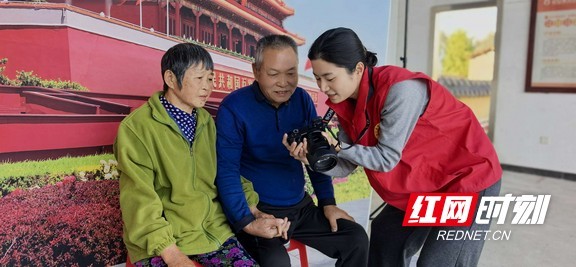 易璟瑶向村民展示拍摄照片。