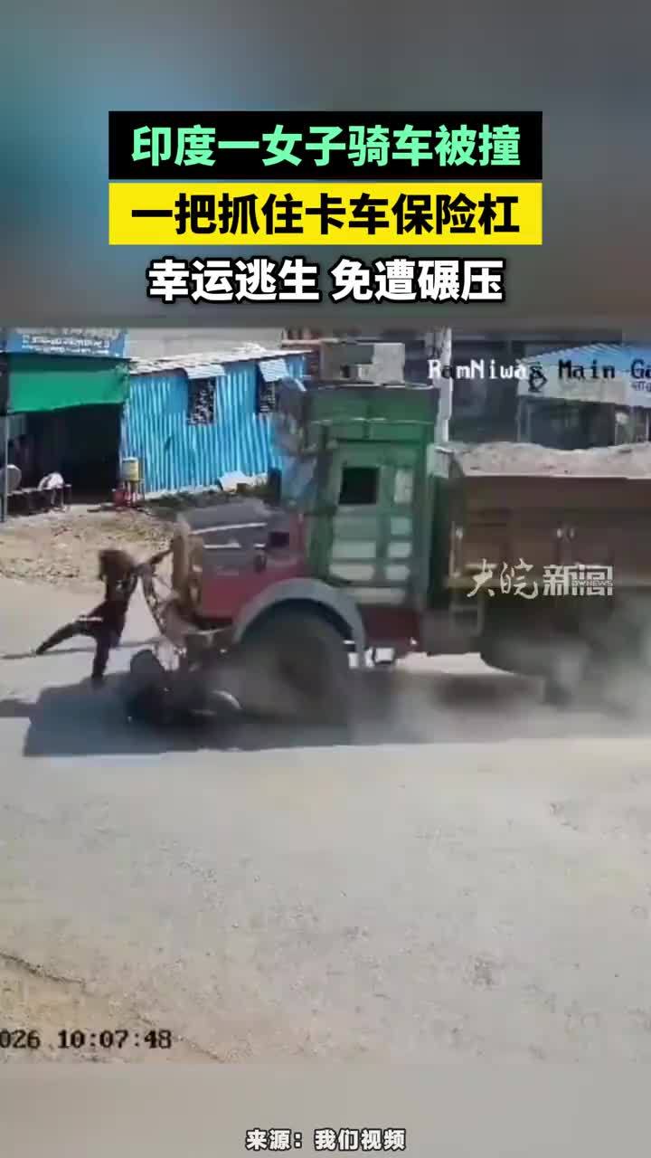 印度一女子骑车被撞，一把抓住卡车保险杠，幸运逃生免遭碾压#印度女子被撞抓住车保险杠逃生