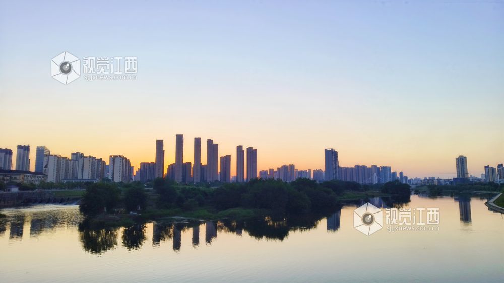 2026年10月8日，江西省宜春市袁州新城，黄昏时分秀江水面平静，两岸高楼的倒影映在江中，水天一色，尽显城市滨江生态之美。