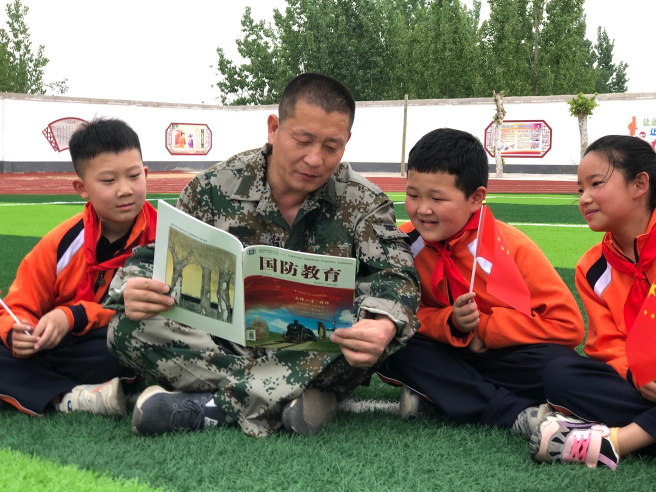 “兵教师”丁太成利用课间为学生讲解国防知识