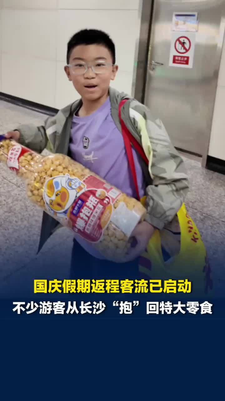 国庆假期返程客流启动，不少游客从长沙“抱”回特大零食，有游客带辣味零食给家人挑战