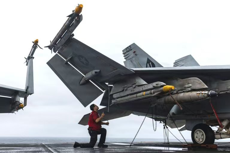 美军地勤人员正在给“黑桃A”中队F/A-18F“超级大黄蜂”战斗机挂在JDAM炸弹以及AIM-9X空空导弹