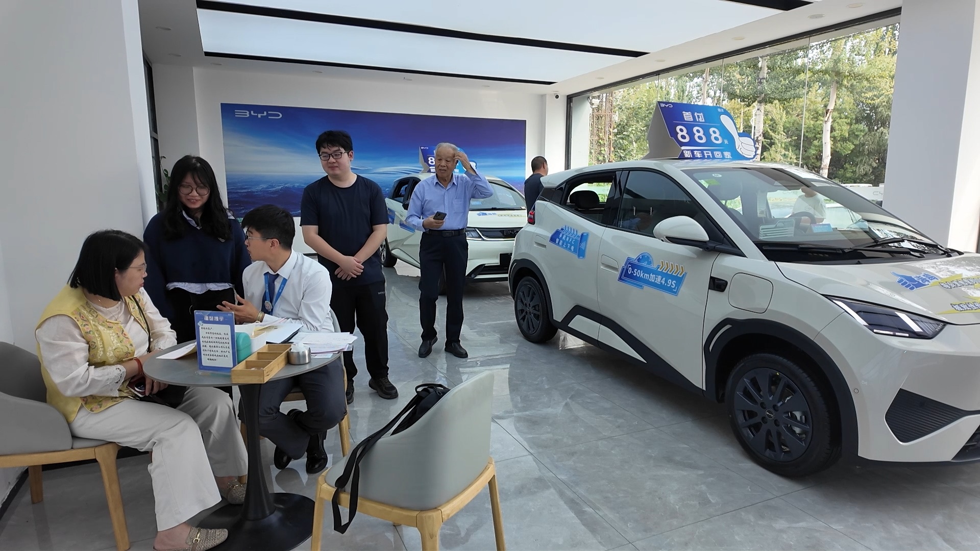 国庆期间,李旗庄汽车小镇展厅内,多组顾客正在咨询购车优惠并体验展车,尽享一站式购车体验。李铁 摄
