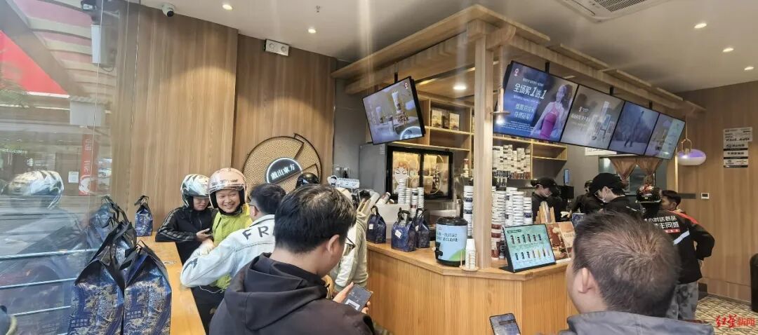 ▲外卖骑手等待领取饮品 张杨 摄