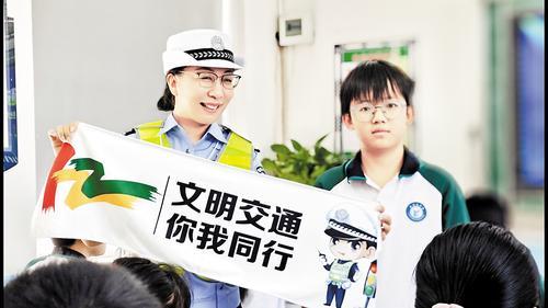 保定市高阳县公安局交管大队民警通过趣味问答与学生互动，并发放交通安全文创宣传品。