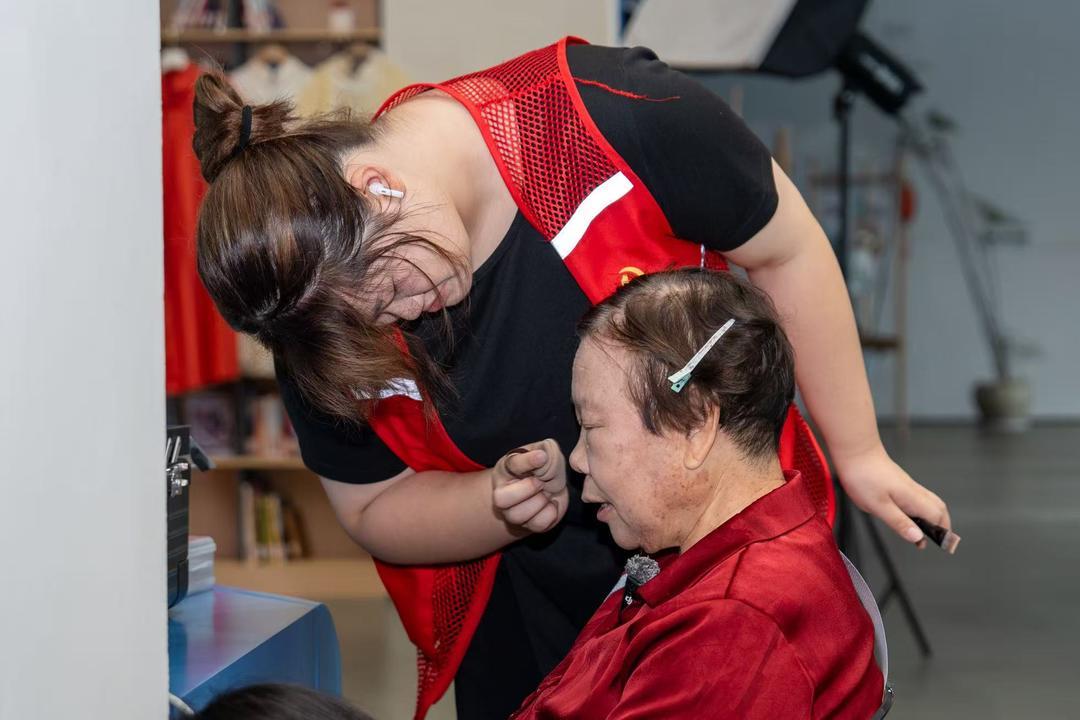 志愿者正在为老人化妆 孙帅琦 摄