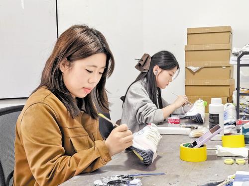 十月十日，邯郸市涧行科技服务有限公司手绘工作室内，企业员工正在运动鞋上手绘图案。本报见习记者 冯依凡摄
