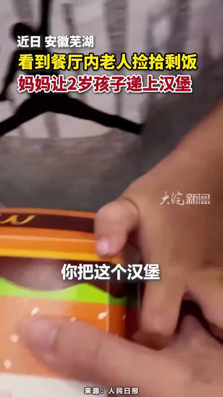 看到餐厅内老人捡拾剩饭，妈妈让2岁孩子递上汉堡