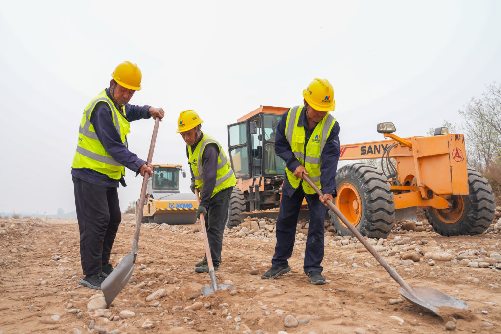 10月12日，涿州市北拒马河调蓄工程施工现场，建设者正在进行巡河路路基找平作业。